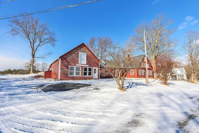 view of snow covered back of property