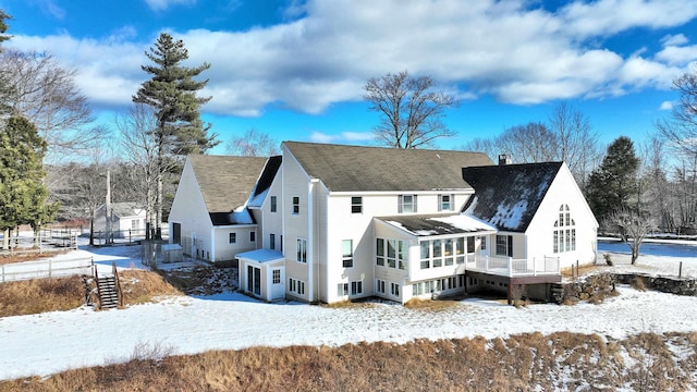 snow covered house with a sunroom