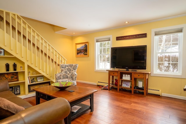 living room featuring baseboard heating, crown molding, and hardwood / wood-style floors