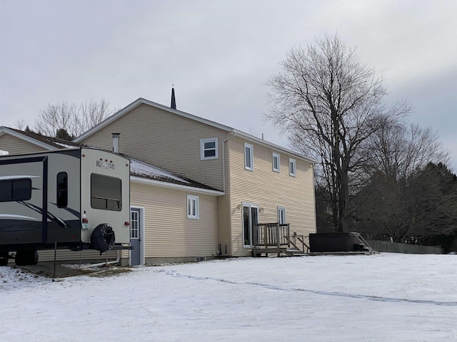 view of snow covered back of property