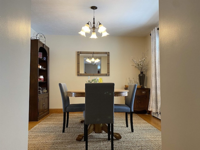 dining space with light hardwood / wood-style flooring and a chandelier