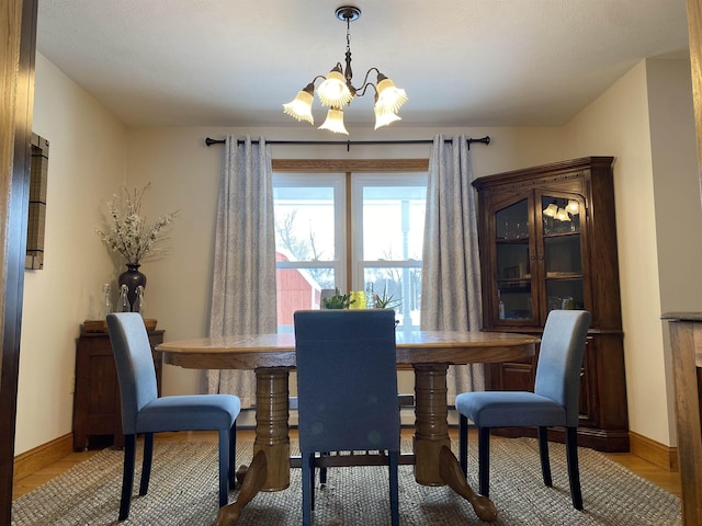 dining space with light hardwood / wood-style floors and a notable chandelier