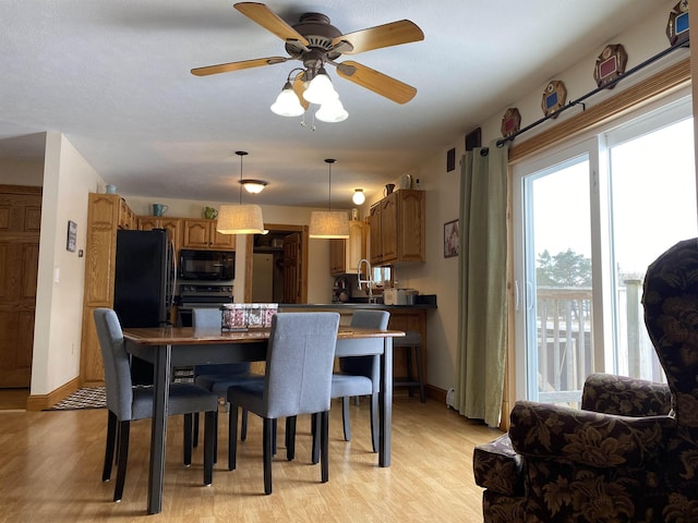 dining space featuring light wood-type flooring and ceiling fan