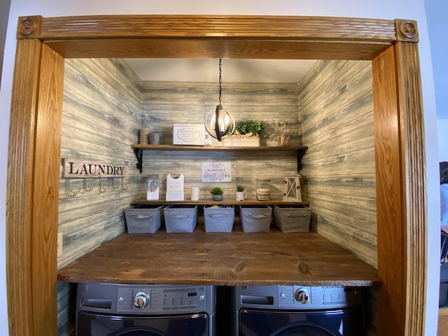 interior space with wood walls and washing machine and clothes dryer