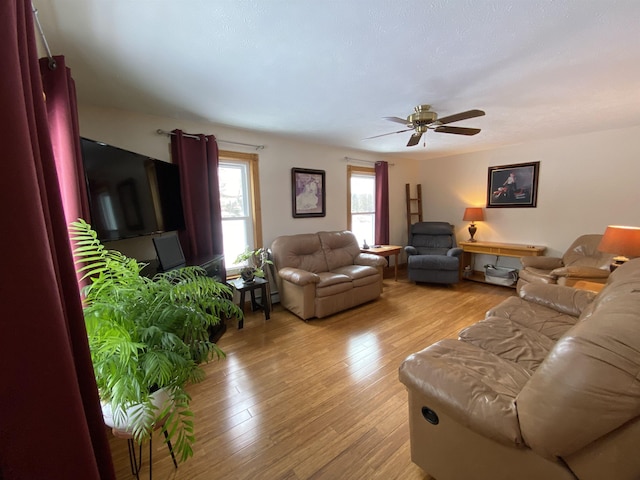 living room featuring ceiling fan and light hardwood / wood-style floors