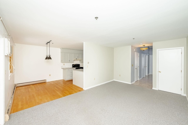 unfurnished living room featuring light colored carpet and a baseboard heating unit