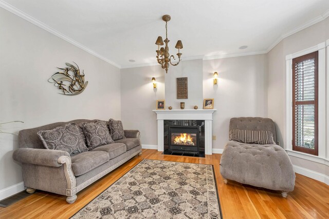 living room featuring wood-type flooring, a tile fireplace, a wealth of natural light, and a chandelier