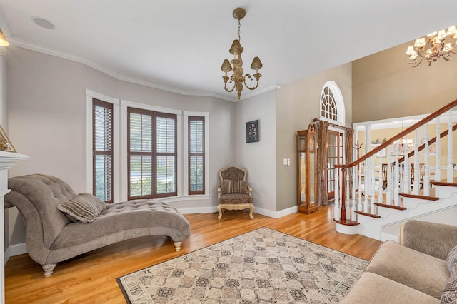 sitting room with ornamental molding, a chandelier, and hardwood / wood-style flooring