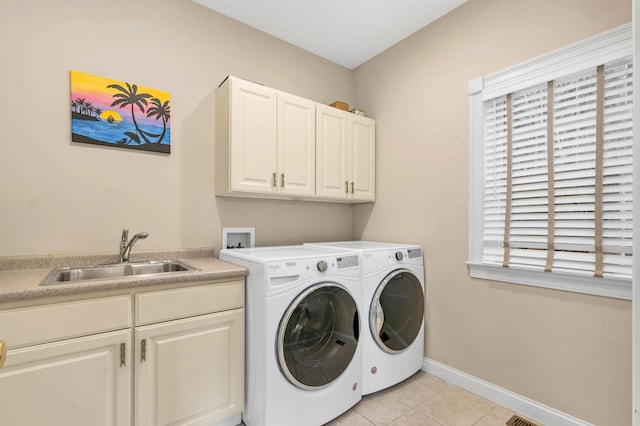 laundry room featuring cabinets, sink, light tile patterned floors, and washing machine and clothes dryer