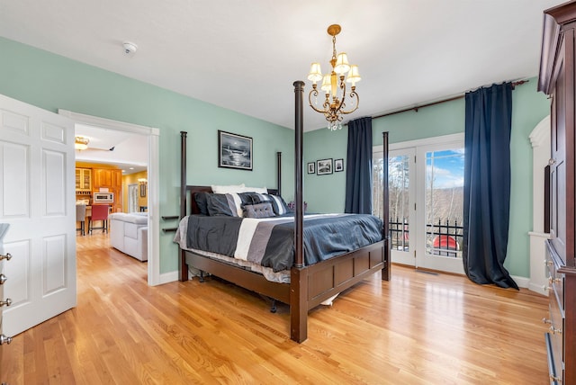 bedroom with light hardwood / wood-style floors, access to exterior, and a notable chandelier