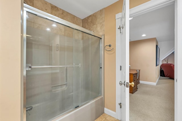 bathroom with bath / shower combo with glass door and tile patterned floors