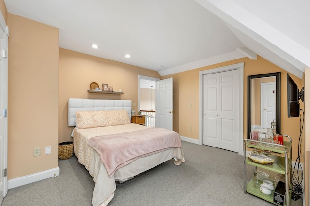 carpeted bedroom with a closet and lofted ceiling