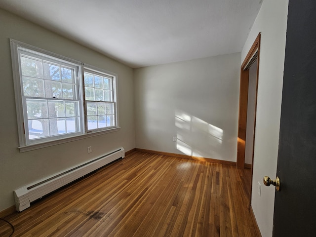 unfurnished room with dark hardwood / wood-style flooring and a baseboard radiator