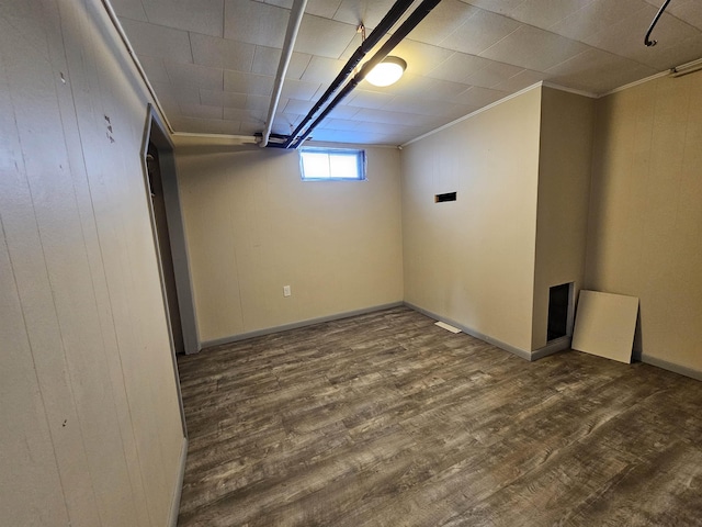 basement featuring dark hardwood / wood-style floors and crown molding