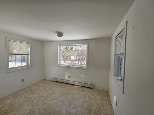 carpeted spare room featuring a baseboard radiator and a wealth of natural light