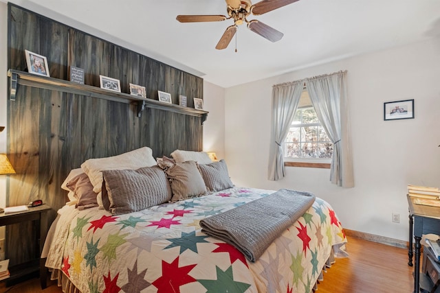 bedroom featuring light wood-type flooring, a ceiling fan, and baseboards