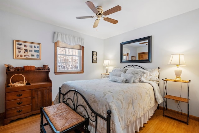 bedroom with light wood finished floors, baseboards, and a ceiling fan