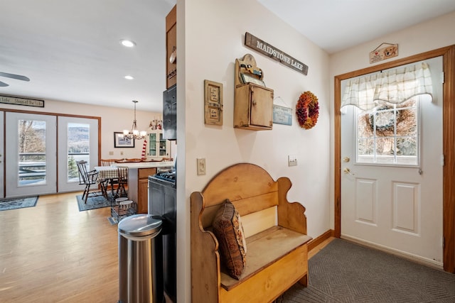 interior space with light wood-style flooring, ceiling fan with notable chandelier, baseboards, and recessed lighting