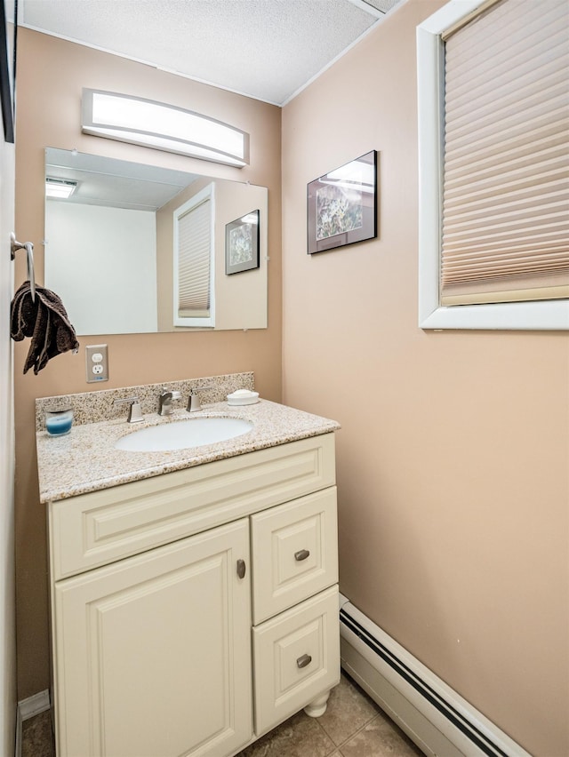 bathroom with a baseboard heating unit, tile patterned flooring, and vanity