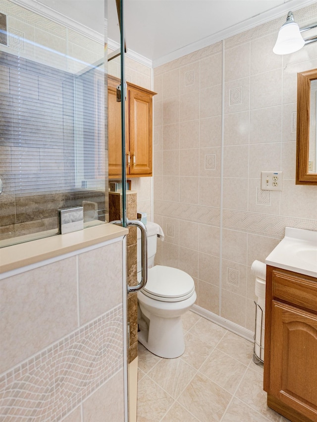 bathroom featuring toilet, vanity, tile patterned flooring, tile walls, and crown molding