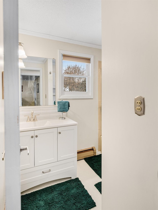 bathroom featuring vanity, a baseboard heating unit, ornamental molding, and a textured ceiling