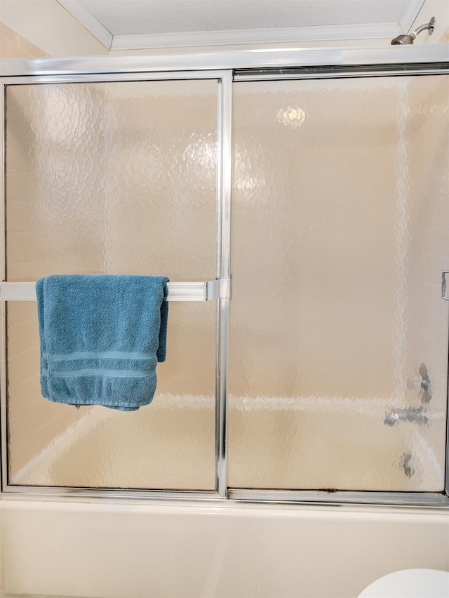 bathroom featuring bath / shower combo with glass door, toilet, and ornamental molding