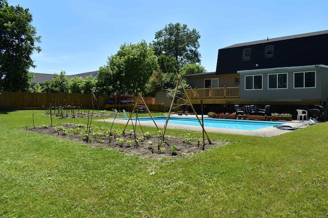 view of pool with a lawn, a deck, and a playground