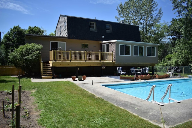 rear view of property featuring a pool side deck and a yard