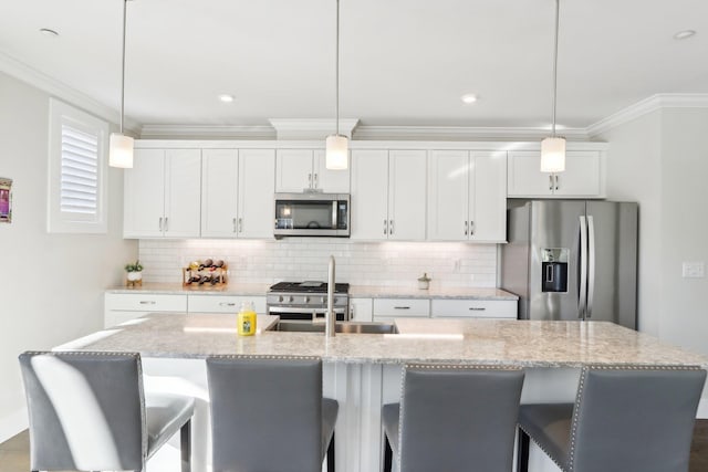 kitchen featuring pendant lighting, white cabinetry, a kitchen island with sink, stainless steel appliances, and light stone counters