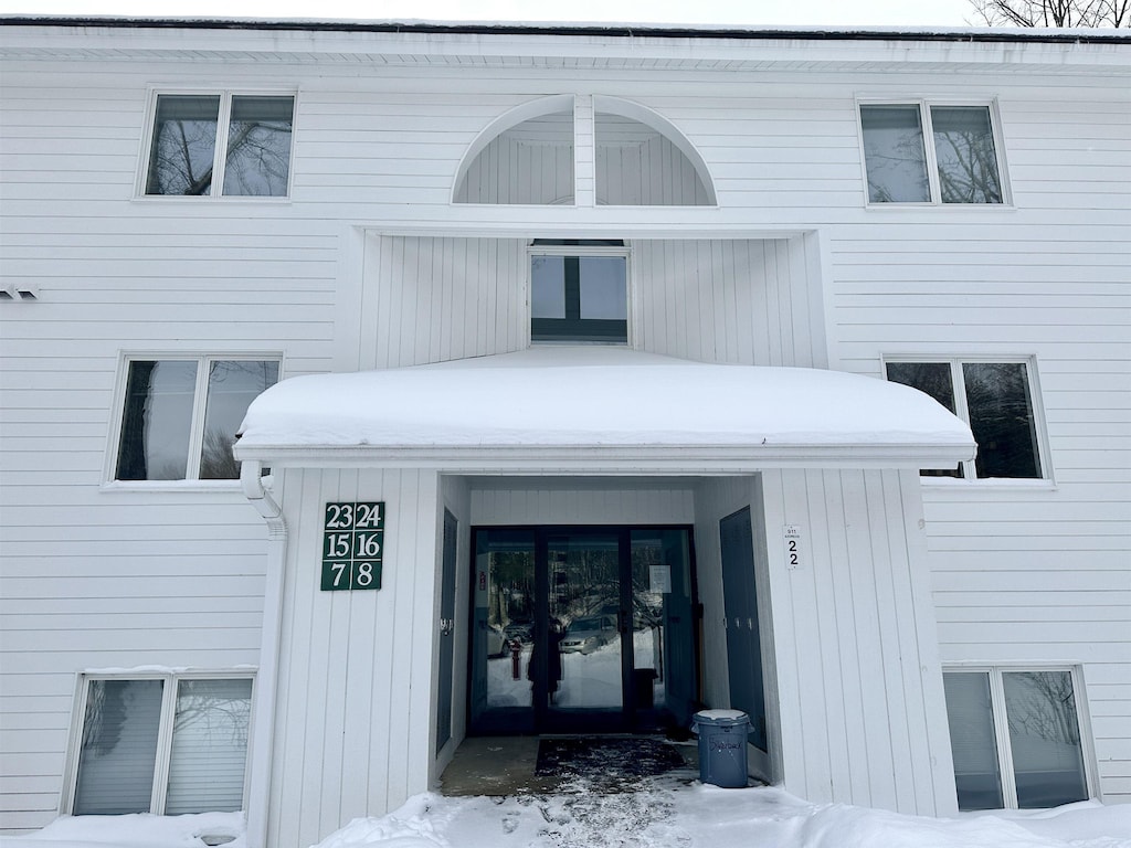 snow covered property entrance with french doors