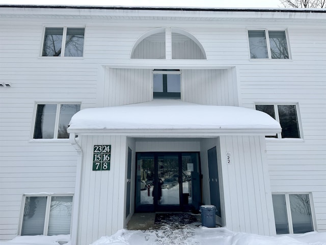 snow covered property entrance with french doors