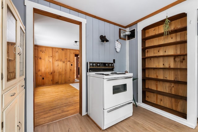 kitchen with light hardwood / wood-style floors, wood walls, ornamental molding, and white electric range