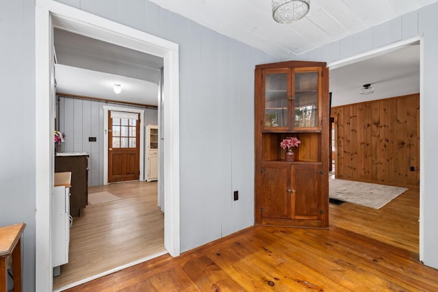 hall featuring wooden walls and light hardwood / wood-style floors