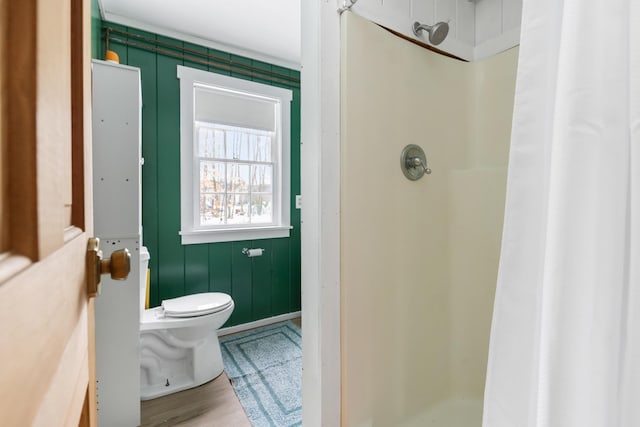 bathroom featuring toilet, hardwood / wood-style floors, and walk in shower