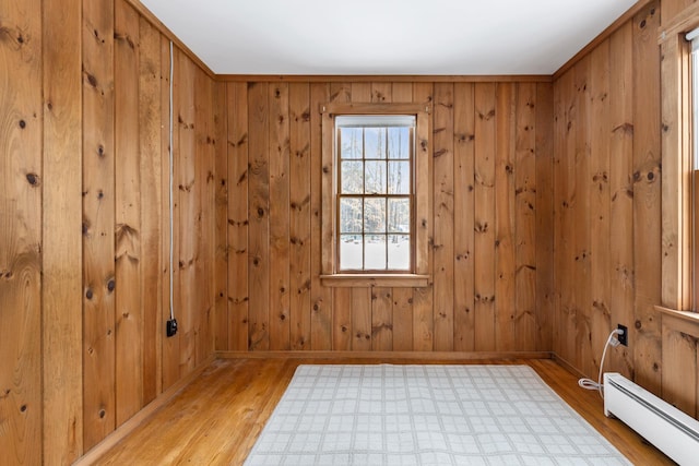 unfurnished room with a baseboard radiator, light hardwood / wood-style flooring, and crown molding