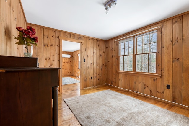 interior space with light hardwood / wood-style floors and wooden walls