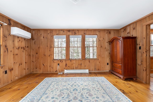 empty room with a wall unit AC, baseboard heating, crown molding, and light hardwood / wood-style flooring