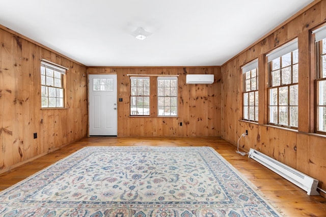 entrance foyer with a healthy amount of sunlight, a wall unit AC, light hardwood / wood-style floors, and a baseboard radiator