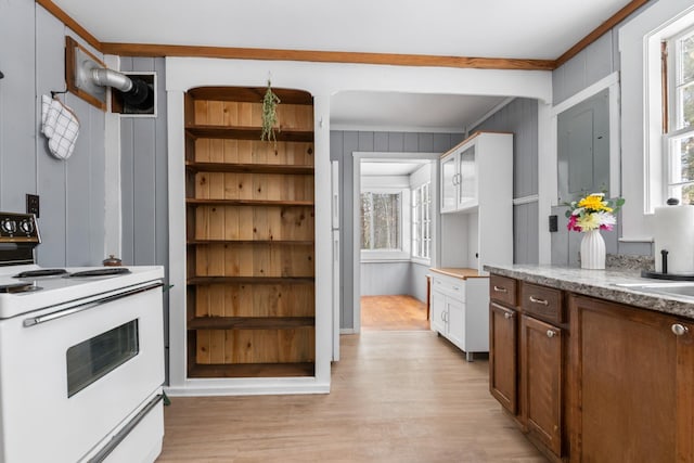 kitchen with light wood-type flooring, white electric range, a wealth of natural light, and white cabinetry