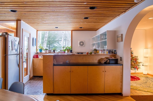 kitchen with wooden ceiling, light wood-type flooring, and stainless steel refrigerator