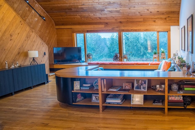 interior space with wood walls, wooden ceiling, track lighting, wood-type flooring, and vaulted ceiling