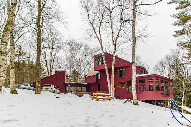 yard covered in snow with a sunroom