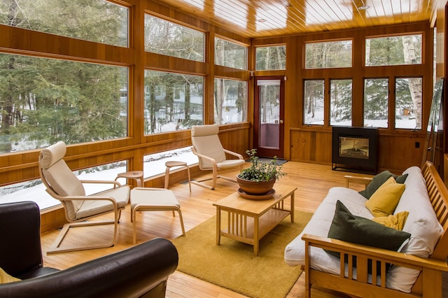 sunroom / solarium with a multi sided fireplace and wood ceiling