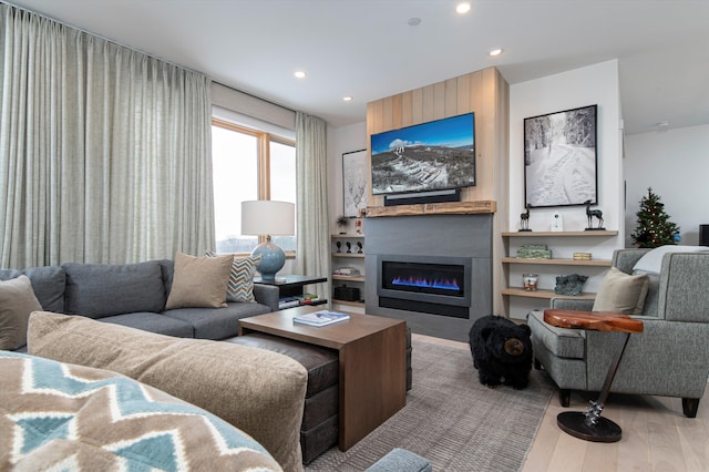 living room featuring wood-type flooring and a large fireplace