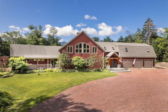 view of front of home featuring a garage, a front yard, and a porch