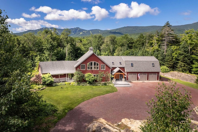 view of front of house with a front yard, a garage, and a mountain view