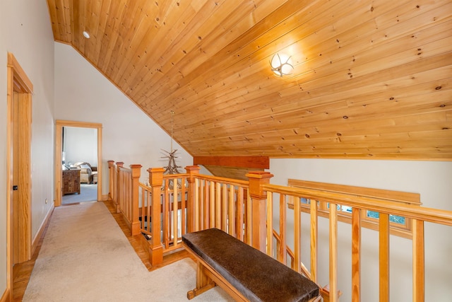 hallway with lofted ceiling, light colored carpet, and wood ceiling