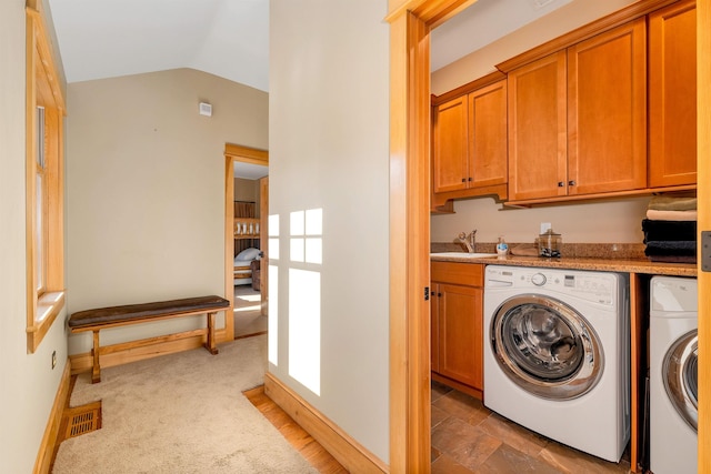 laundry area with dark colored carpet, sink, separate washer and dryer, and cabinets