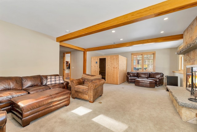 living room with light carpet, beam ceiling, and a stone fireplace