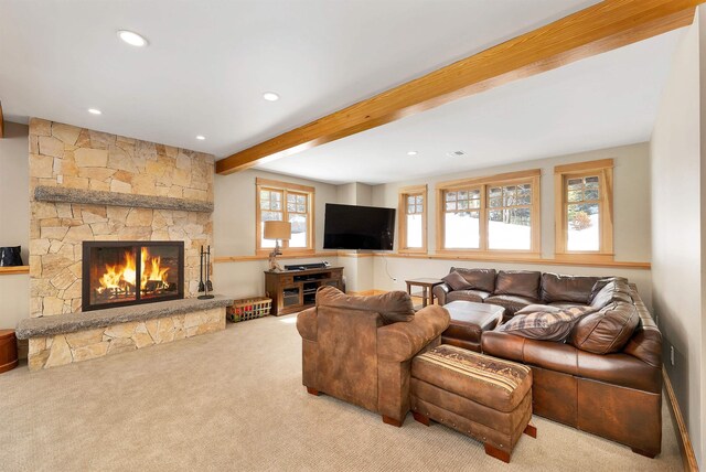 carpeted living room featuring beamed ceiling and a fireplace